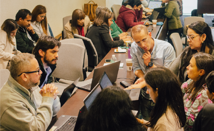 Grupo de profesionales en una reunión de trabajo colaborativa en un entorno corporativo
